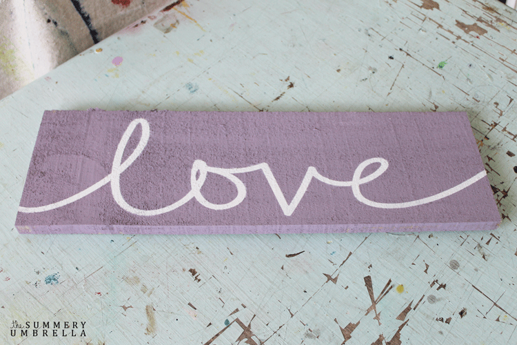 A distressed wood sign with the word love on it