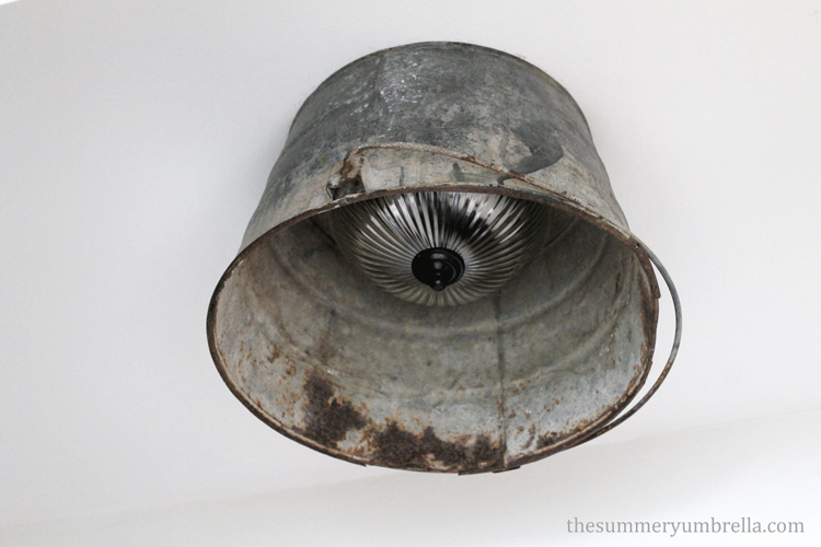 Looking for an interesting way to update that old boob light? Try this DIY Rustic and Industrial Bucket Light tutorial for an unique look!