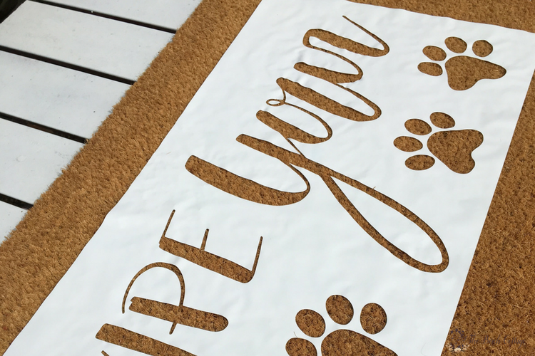 Create this easy Wipe Your Paws DIY Personalized Doormat with your Cricut to add some personality to your home. Come learn how to paint a coir doormat using a stencil and outdoor paint! #diydoormat #frontporch #cricut #cutfile #svgcutfiles #SVG #thesummeryumbrella