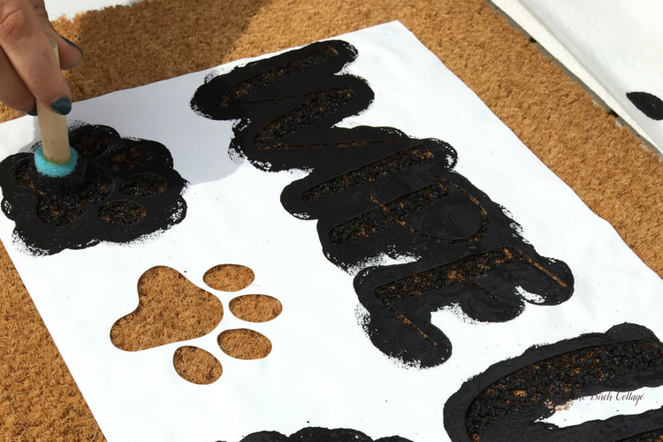 Create this easy Wipe Your Paws DIY Personalized Doormat with your Cricut to add some personality to your home. Come learn how to paint a coir doormat using a stencil and outdoor paint! #diydoormat #frontporch #cricut #cutfile #svgcutfiles #SVG #thesummeryumbrella