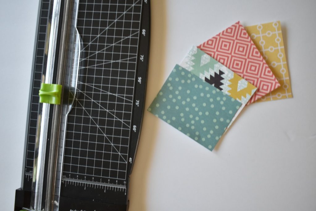 a paper trimmer is being used to cut rectangles out of scrapbook paper