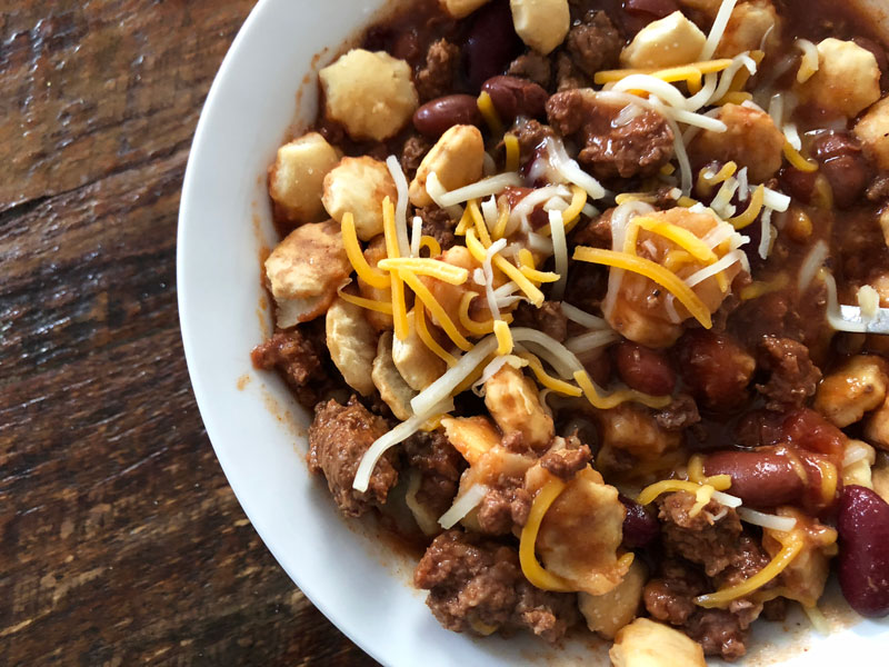 Steaming bowl of hearty chili topped with cheese