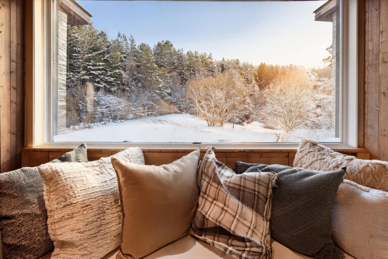 Cushion-filled window seat overlooking snowy scene